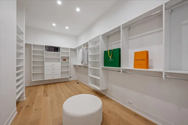 a view of an empty room with wooden floor and windows