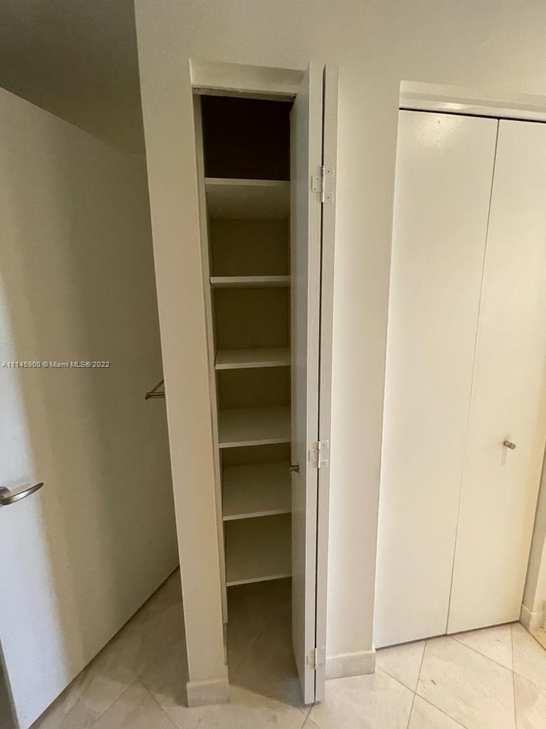 901 Brickell Key Boulevard, Unit 1005 Miami, FL 33131 - Photo 16 of 41 a view of walk in closet with empty racks