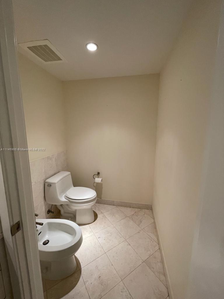 901 Brickell Key Boulevard, Unit 1005 Miami, FL 33131 - Photo 17 of 41 a white toilet sitting next to a white cabinet