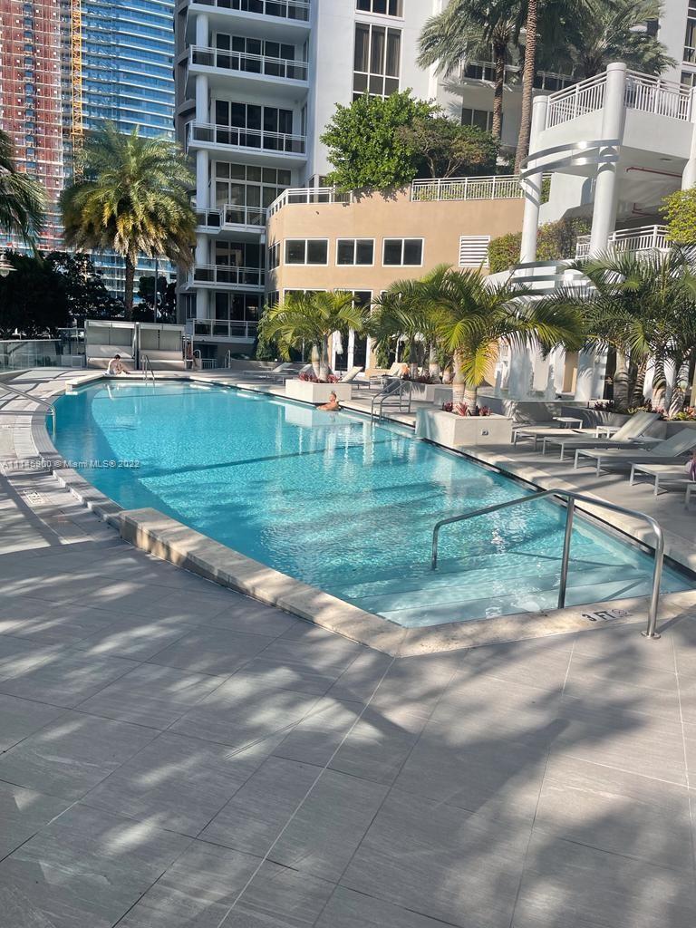 901 Brickell Key Boulevard, Unit 1005 Miami, FL 33131 - Photo 26 of 41 a view of swimming pool with outdoor seating and plants