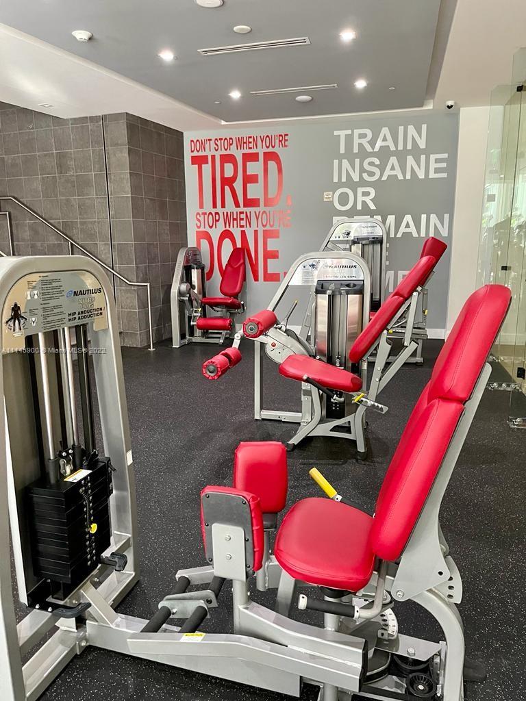 901 Brickell Key Boulevard, Unit 1005 Miami, FL 33131 - Photo 36 of 41 a room with gym equipment and air hockey table