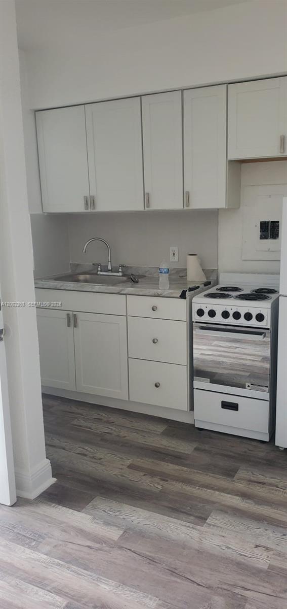 8545 Harding Avenue, Unit 5 Miami Beach, FL 33141 - Photo 7 of 10 a kitchen with granite countertop white cabinets and stainless steel appliances