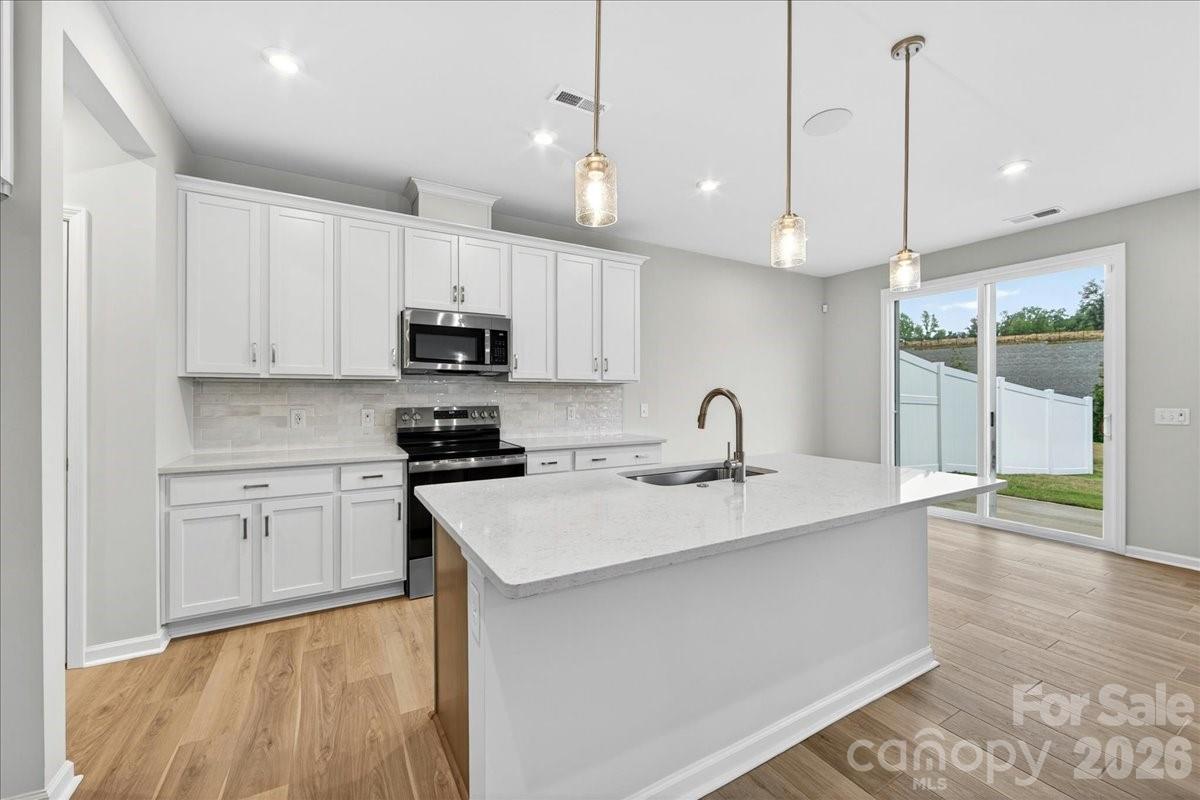 512 Webster Lane Cramerton, NC 28032 - Photo 5 of 28 a kitchen with kitchen island a sink stainless steel appliances and cabinets