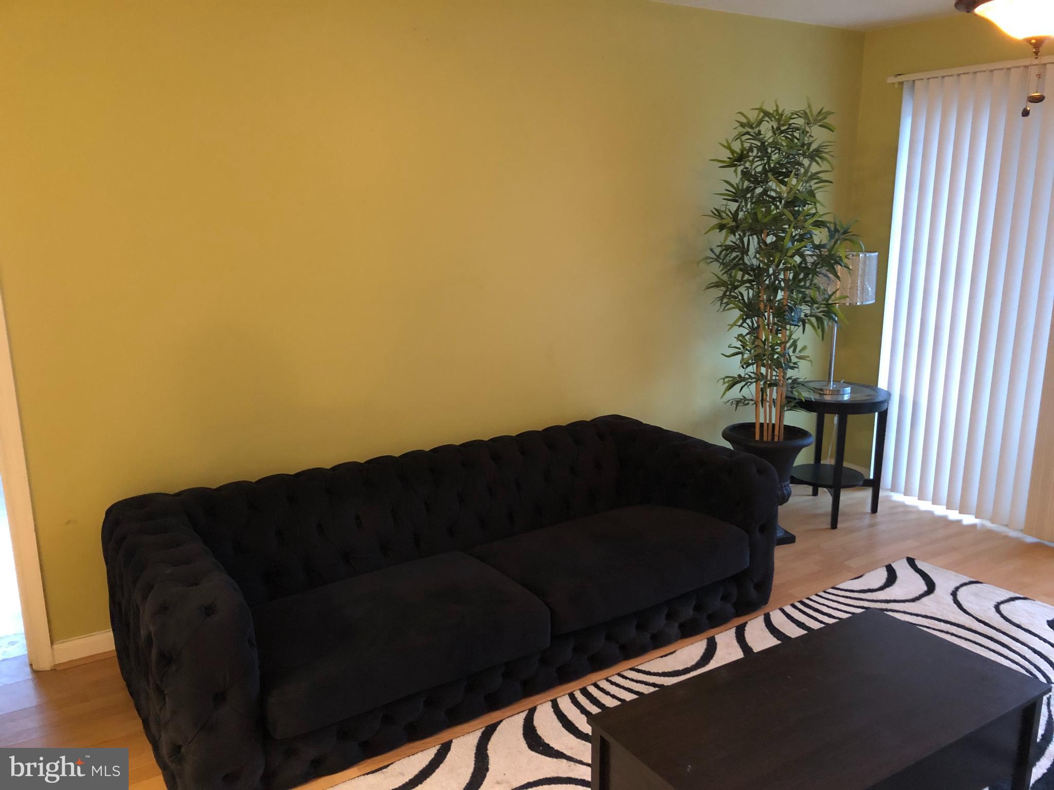 1055 Gardenview Loop, Unit 304 Woodbridge, VA 22191 - Photo 14 of 70 a black leather couch sitting in a living room next to a window