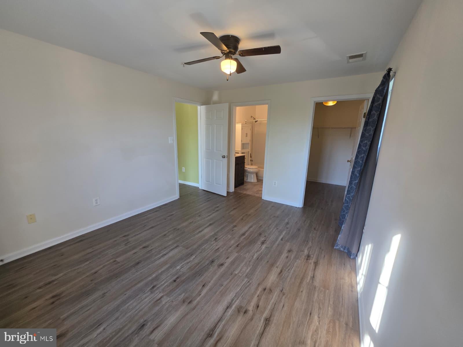 1055 Gardenview Loop, Unit 304 Woodbridge, VA 22191 - Photo 45 of 70 an empty room with wooden floor and a ceiling fan