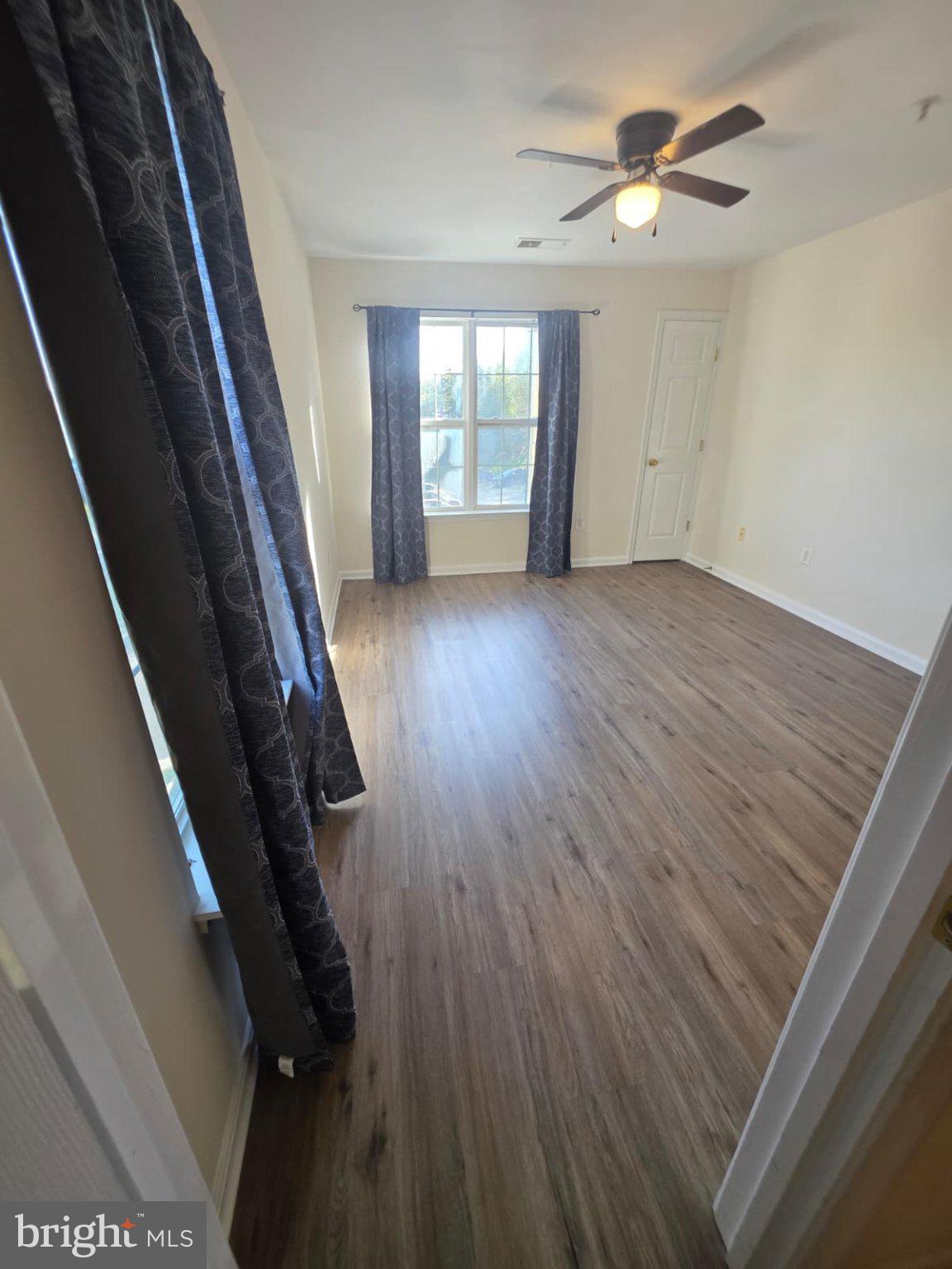 1055 Gardenview Loop, Unit 304 Woodbridge, VA 22191 - Photo 46 of 70 an empty room with wooden floor and windows