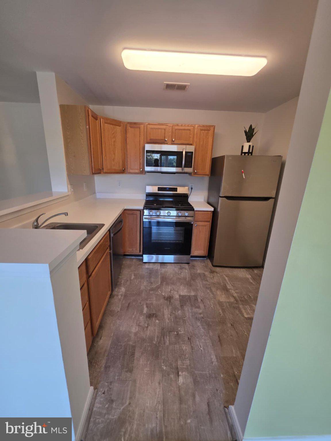 1055 Gardenview Loop, Unit 304 Woodbridge, VA 22191 - Photo 52 of 70 a kitchen with a stove and a refrigerator