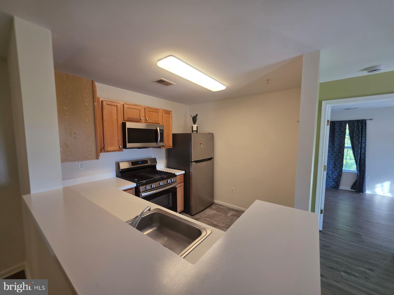1055 Gardenview Loop, Unit 304 Woodbridge, VA 22191 - Photo 53 of 70 a kitchen that has a microwave and a stove top oven