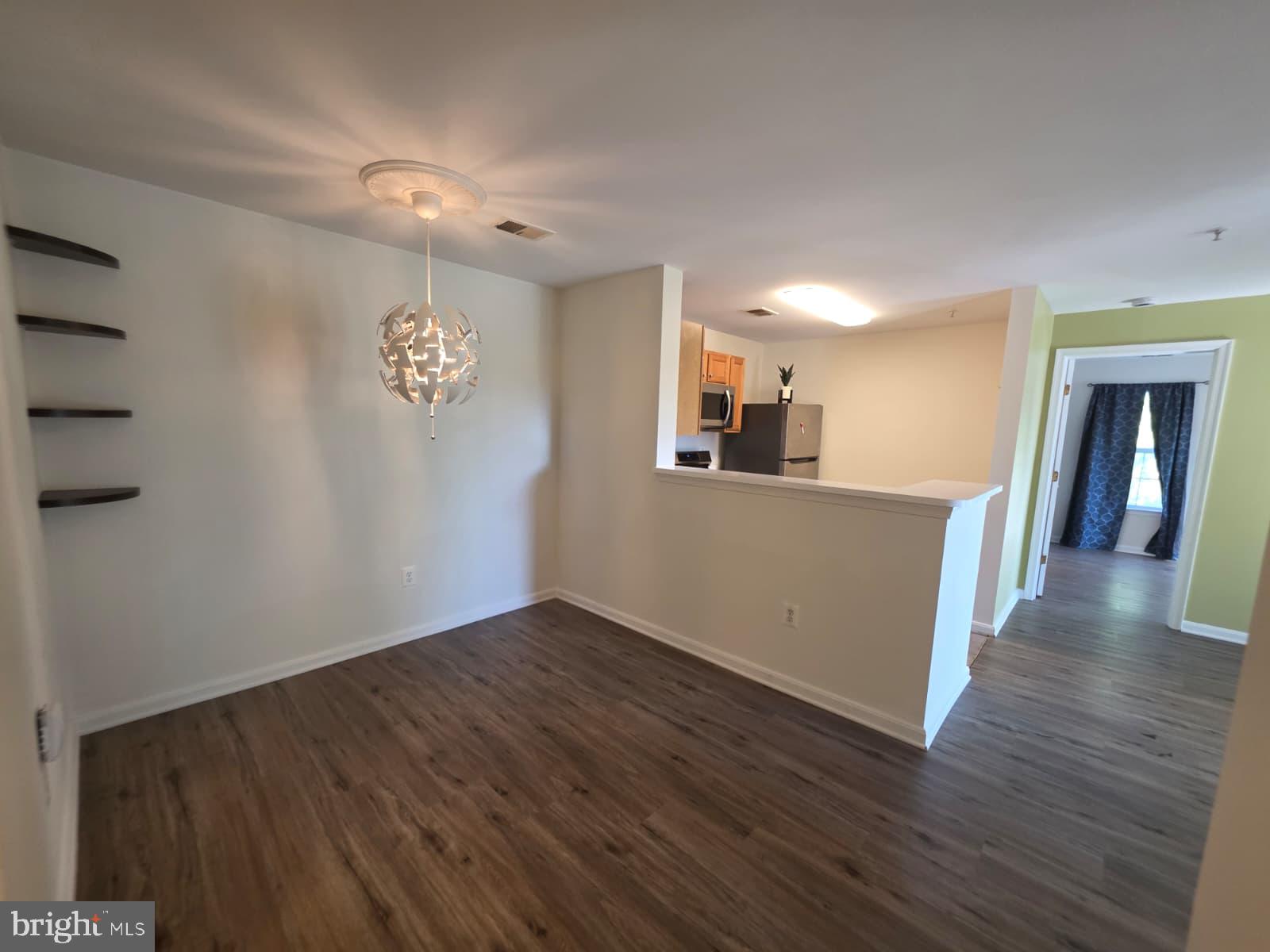 1055 Gardenview Loop, Unit 304 Woodbridge, VA 22191 - Photo 54 of 70 a view of a kitchen with wooden floor and a ceiling fan