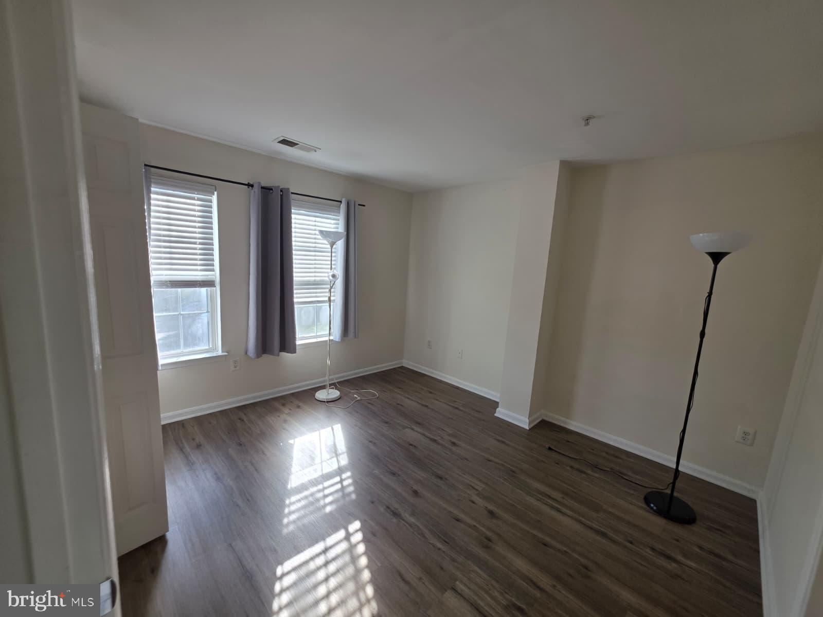 1055 Gardenview Loop, Unit 304 Woodbridge, VA 22191 - Photo 64 of 70 a view of an empty room with wooden floor and a window