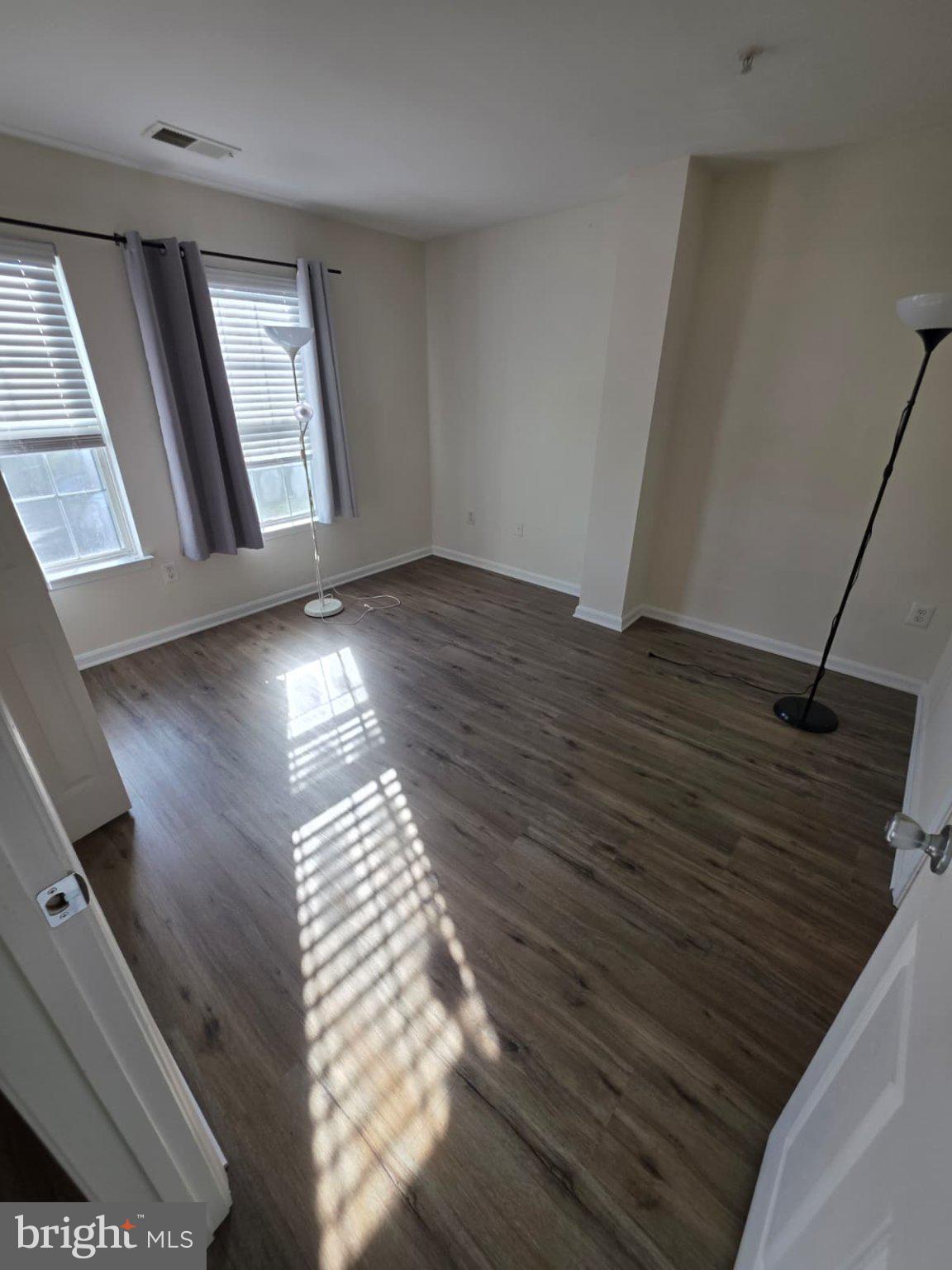 1055 Gardenview Loop, Unit 304 Woodbridge, VA 22191 - Photo 65 of 70 a view of an empty room with wooden floor and a window