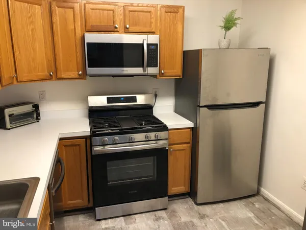 a view of a hallway with wooden floor and bathroom