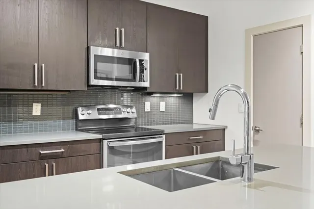 a kitchen with stainless steel appliances granite countertop a stove and a refrigerator