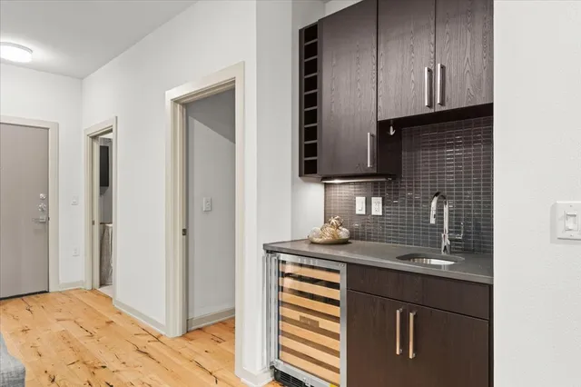 an empty room with a chandelier fan and wooden floor