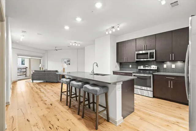 a kitchen with stainless steel appliances granite countertop a stove a microwave and a sink