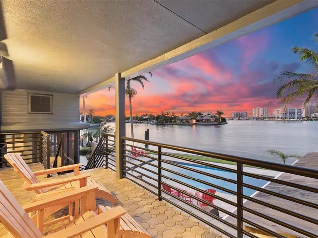 a bedroom with a balcony a bed and a chandelier