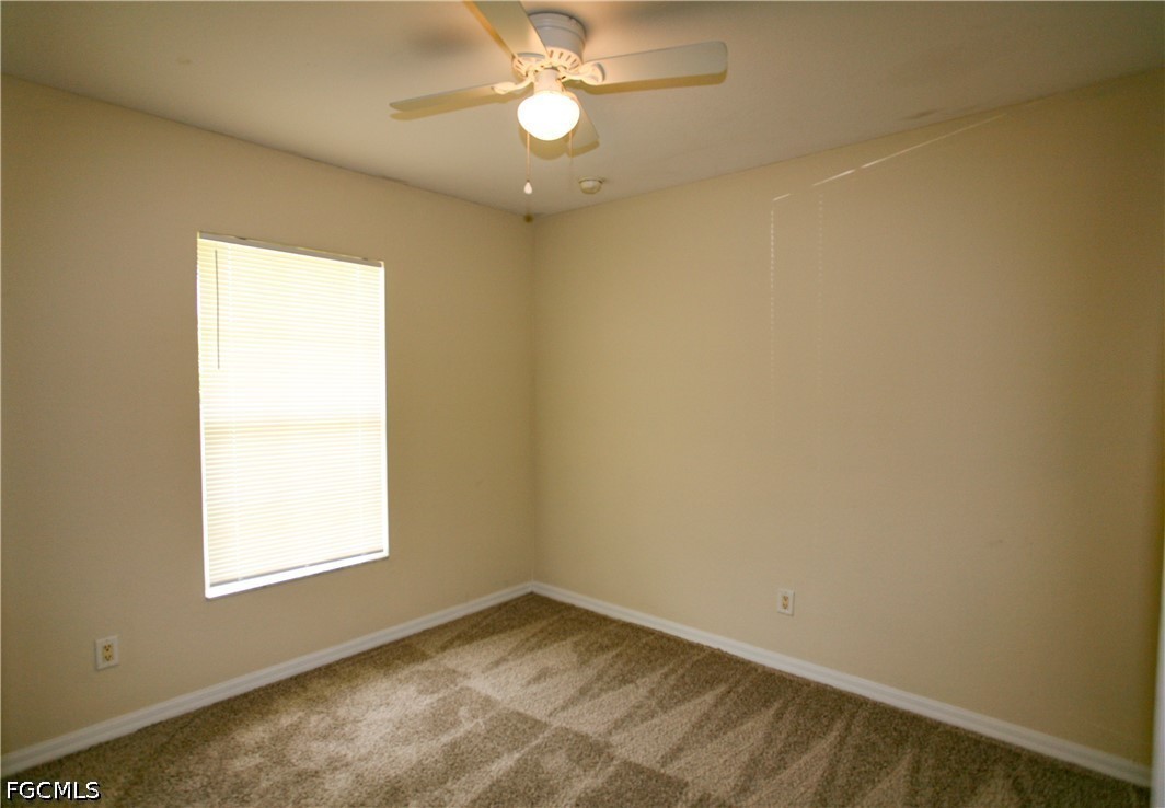 4614 25th Street Southwest Lehigh Acres, FL 33973 - Photo 12 of 15 an empty room with a window and ceiling fan