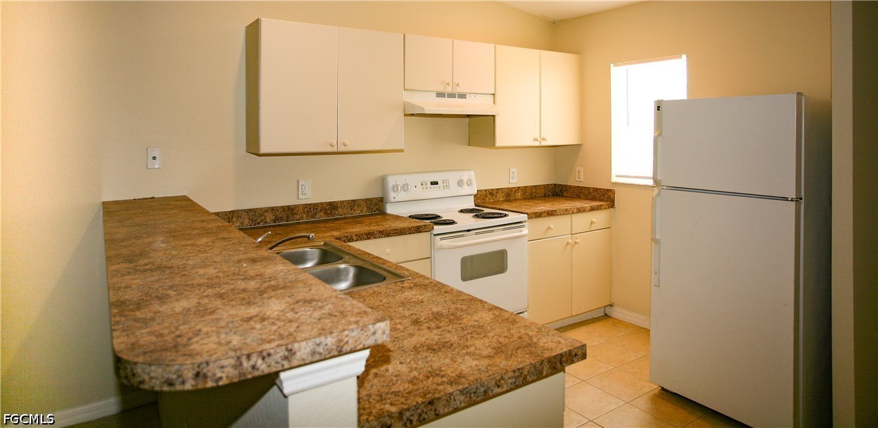 4614 25th Street Southwest Lehigh Acres, FL 33973 - Photo 4 of 15 a kitchen with granite countertop a sink a stove and a refrigerator