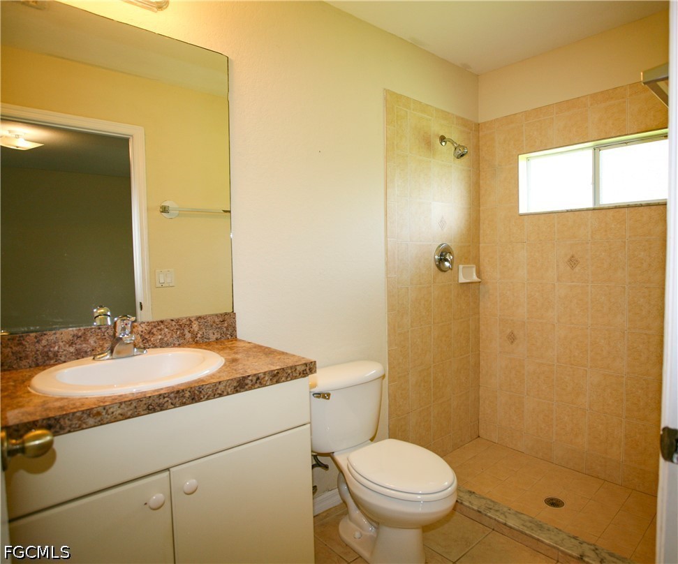 4614 25th Street Southwest Lehigh Acres, FL 33973 - Photo 8 of 15 a bathroom with a granite countertop sink toilet and shower