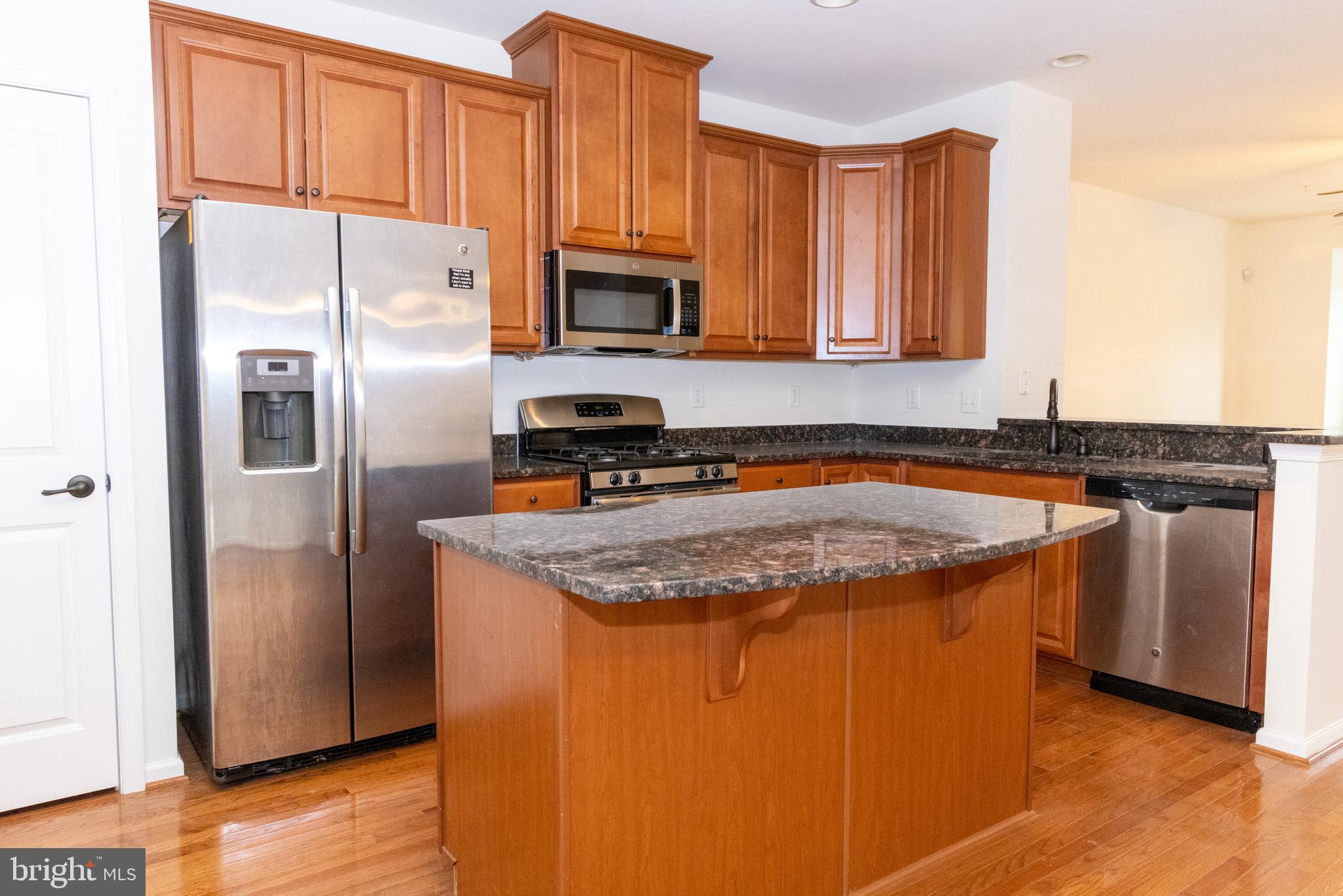7317 Summit Rock Road Elkridge, MD 21075 - Photo 13 of 36 a kitchen with stainless steel appliances granite countertop a refrigerator a stove a sink and a microwave