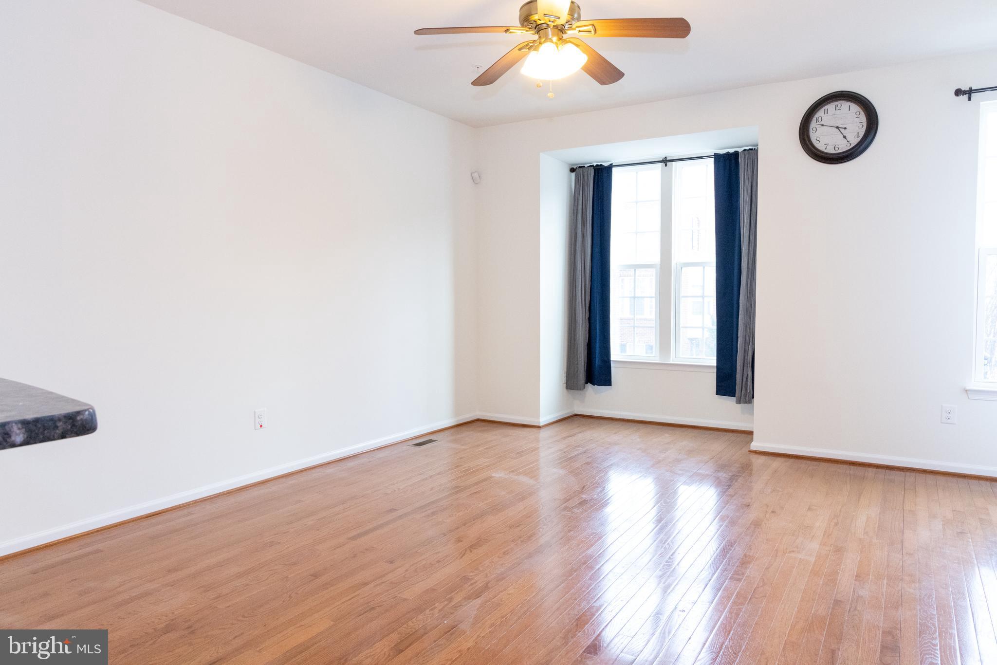 7317 Summit Rock Road Elkridge, MD 21075 - Photo 16 of 36 an empty room with wooden floor fan and windows