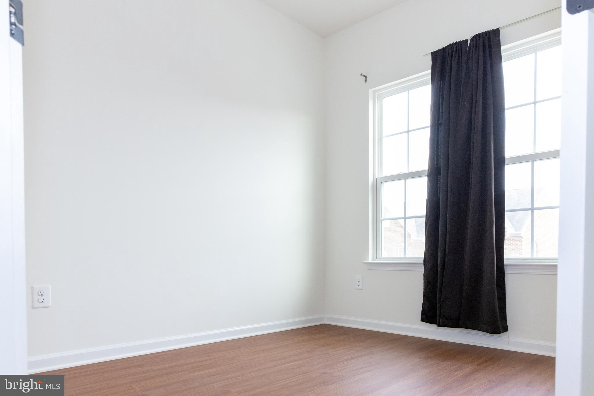 7317 Summit Rock Road Elkridge, MD 21075 - Photo 32 of 36 an empty room with wooden floor and windows