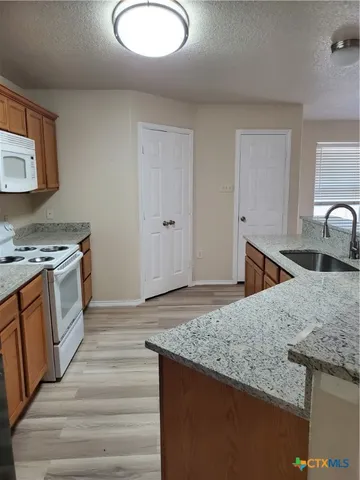 a kitchen with granite countertop a sink and a stove