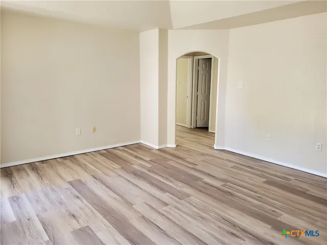 a view of a livingroom with wooden floor and a window