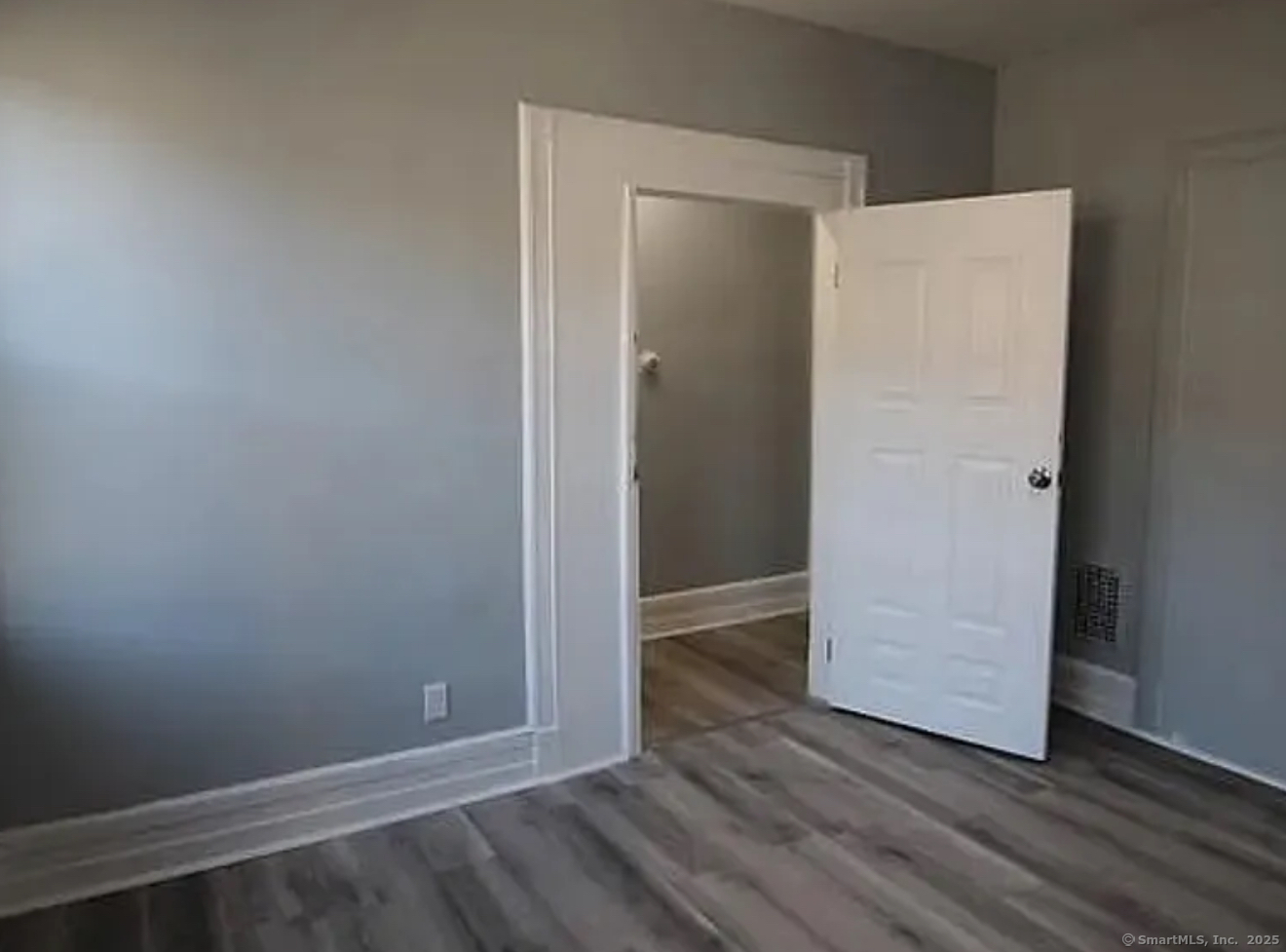 301 Dover Street, Unit 1 Bridgeport, CT 06610 - Photo 3 of 4 an empty room with wooden floor and closet