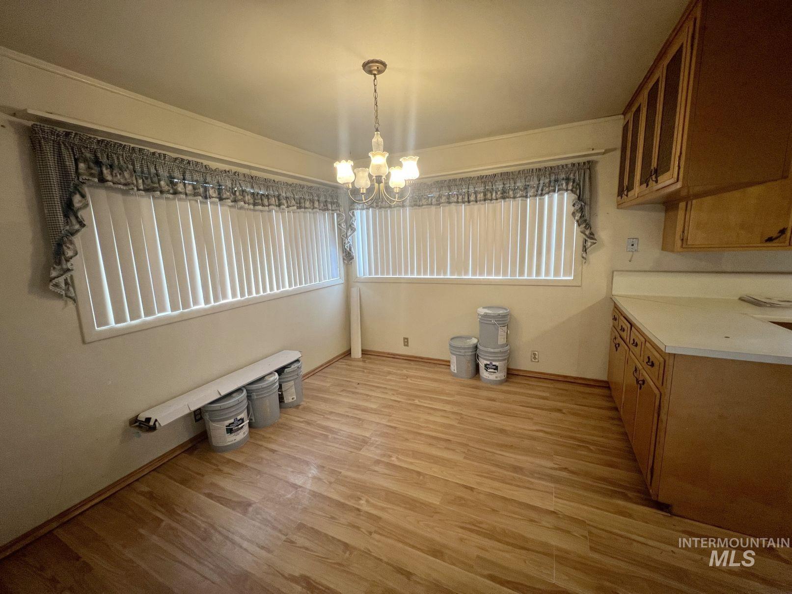 156 West 100 North Jerome, ID 83338 - Photo 5 of 15 Unfurnished dining area featuring light wood finished floors, a chandelier, and healthy amount of natural light