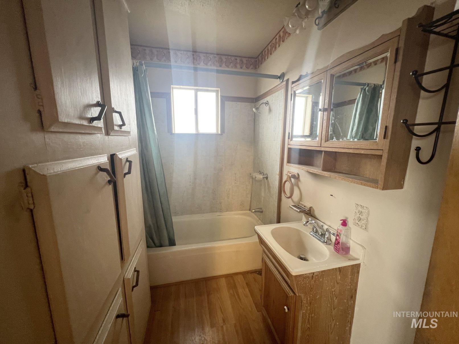 156 West 100 North Jerome, ID 83338 - Photo 6 of 15 Bathroom featuring shower / bathtub combination with curtain, vanity, and dark wood-style flooring