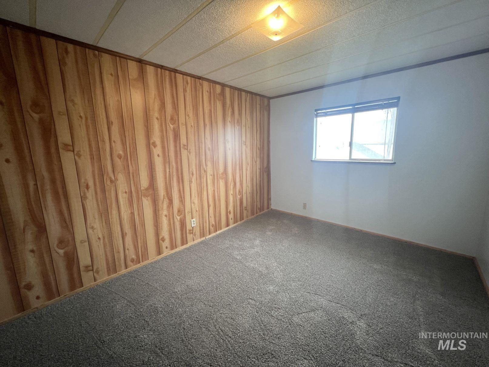 156 West 100 North Jerome, ID 83338 - Photo 7 of 15 Unfurnished room featuring wooden walls and carpet