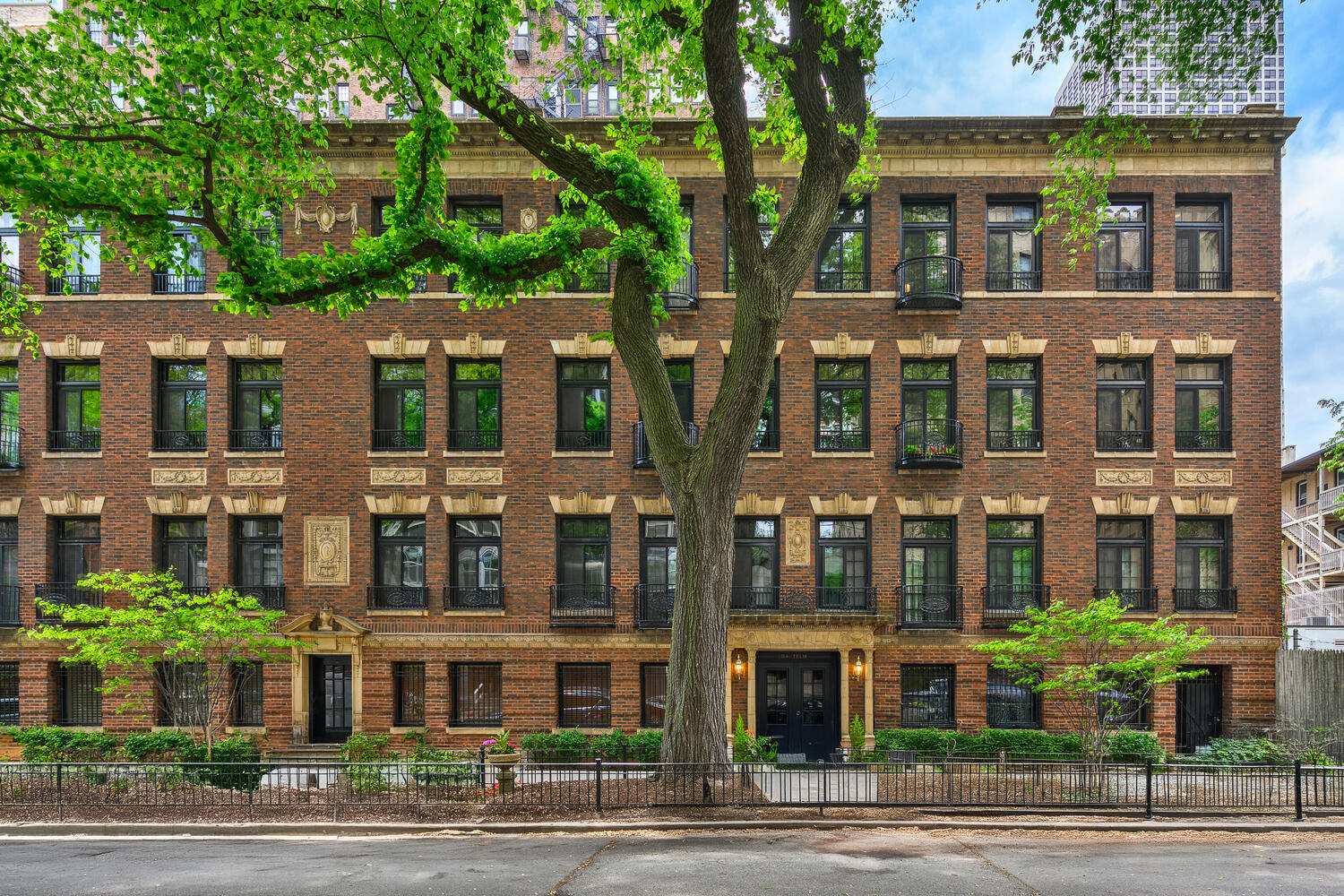 a front view of a multi story building with a yard