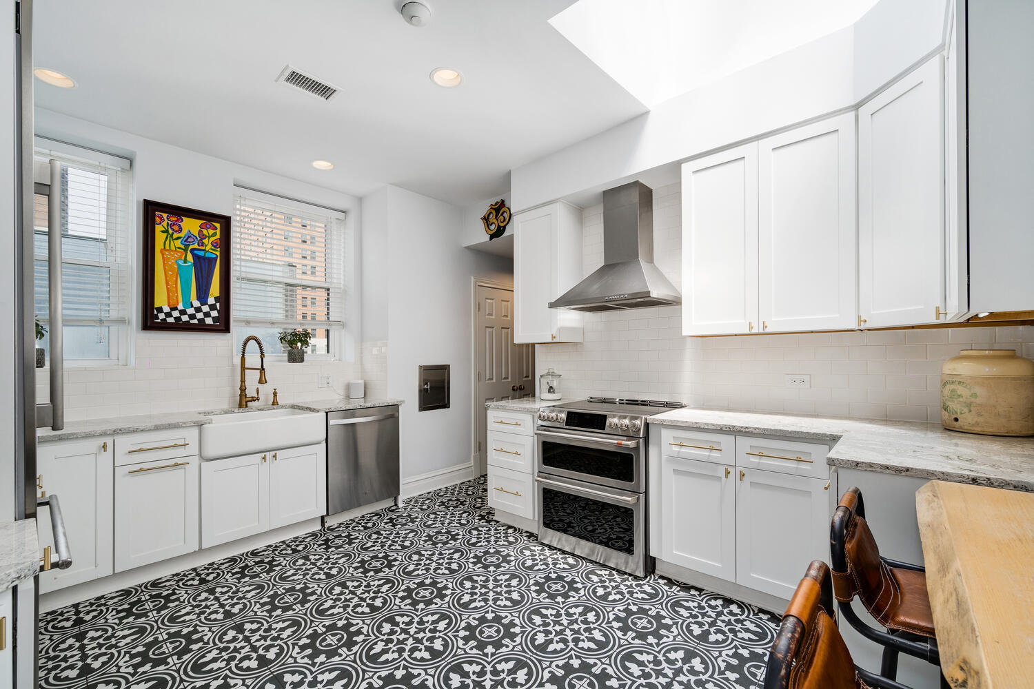 21 East Elm Street, Unit 3D Chicago, IL 60611 - Photo 12 of 27 a kitchen with stainless steel appliances a stove a sink and white cabinets