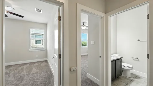 an empty room with a window and a fan