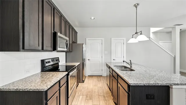 a kitchen with stainless steel appliances granite countertop a sink refrigerator and microwave