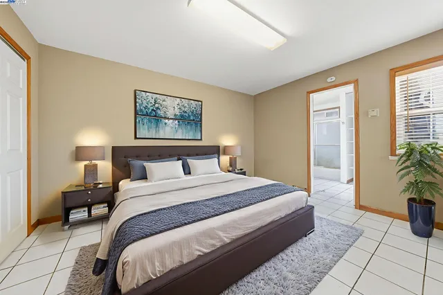 a bedroom with a bed and painting on the wall