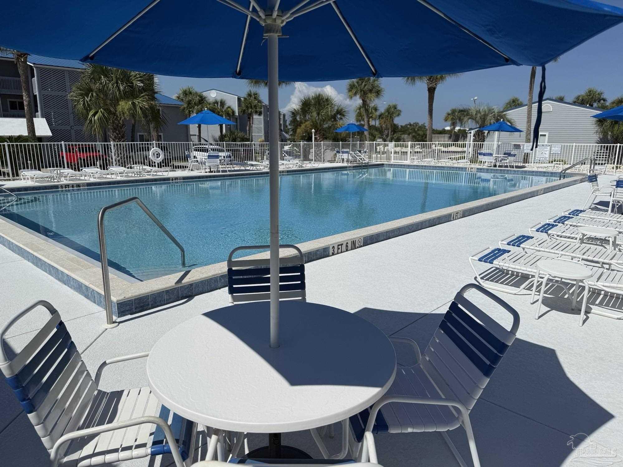 16470 Perdido Key Drive, Unit B13 Perdido Key, FL 32507 - Photo 5 of 17 a view of a patio with table and chairs under an umbrella