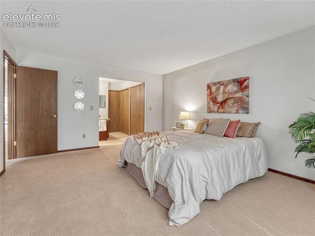 1146 Fontmore Road, Unit A Colorado Springs, CO 80904 - Photo 4 of 24 a spacious bedroom with a bed and a painting on the wall