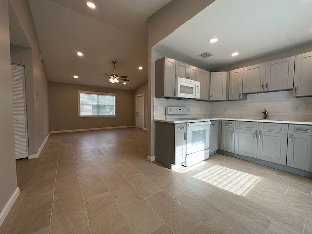 3166 Southeast Garden Street, Unit 3166 Stuart, FL 34997 - Photo 6 of 10 a view of kitchen with windows and fireplace
