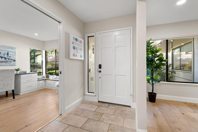 a view of an entryway with wooden floor and a livingroom view