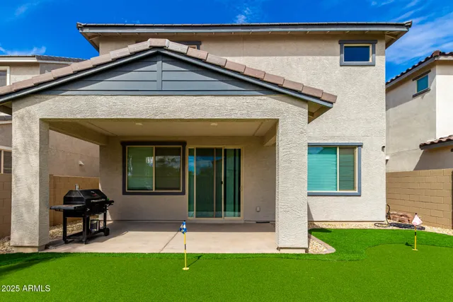 a view of a swimming pool with a lawn chairs under palm trees
