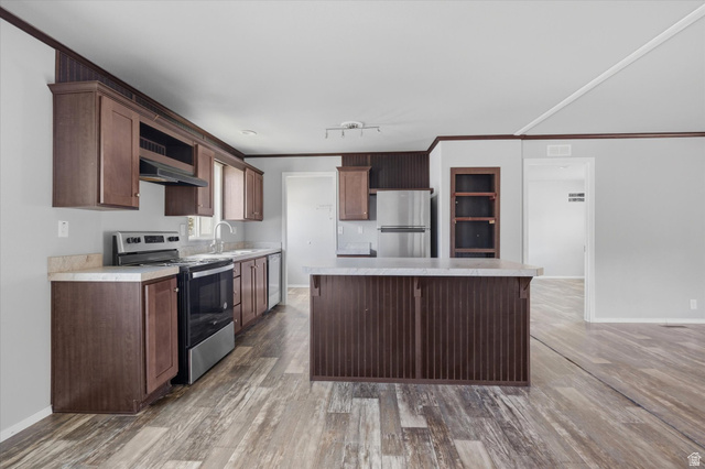 433 North 750 West Logan, UT 84321 - Photo 7 of 40 Kitchen with wood-finish flooring, dark wood cabinetry, a central island, and stainless steel appliances
