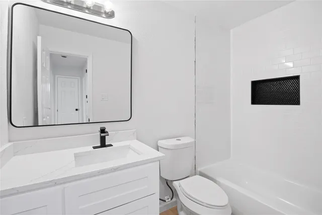 a bathroom with a toilet sink a mirror and vanity
