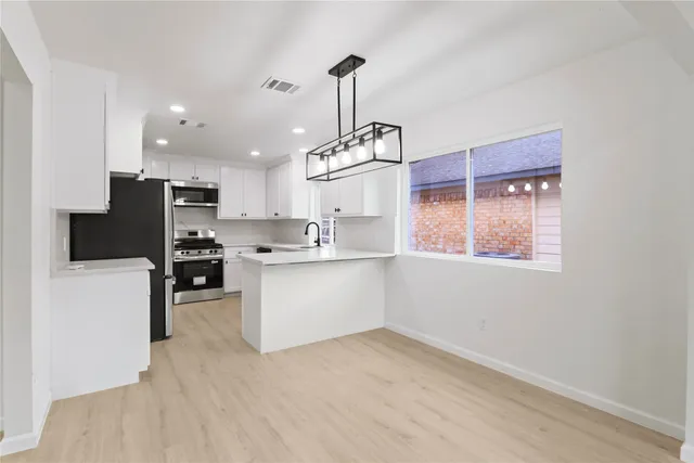 a kitchen with kitchen island white cabinets and refrigerator