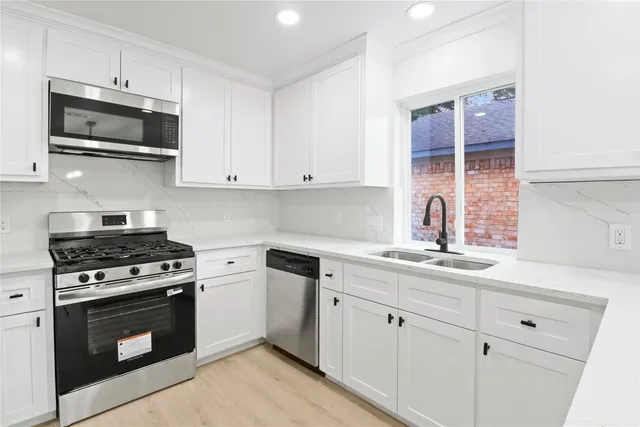 a kitchen with appliances a sink and cabinets