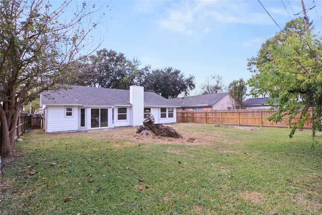 a view of a yard in front of a house with large tree