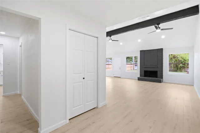 an empty room with windows and fireplace