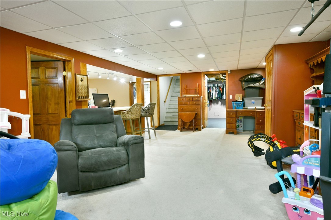 2847 Selkirk Bush Road Warren, OH 44481 - Photo 30 of 47 Carpeted living room with stairway and a drop ceiling