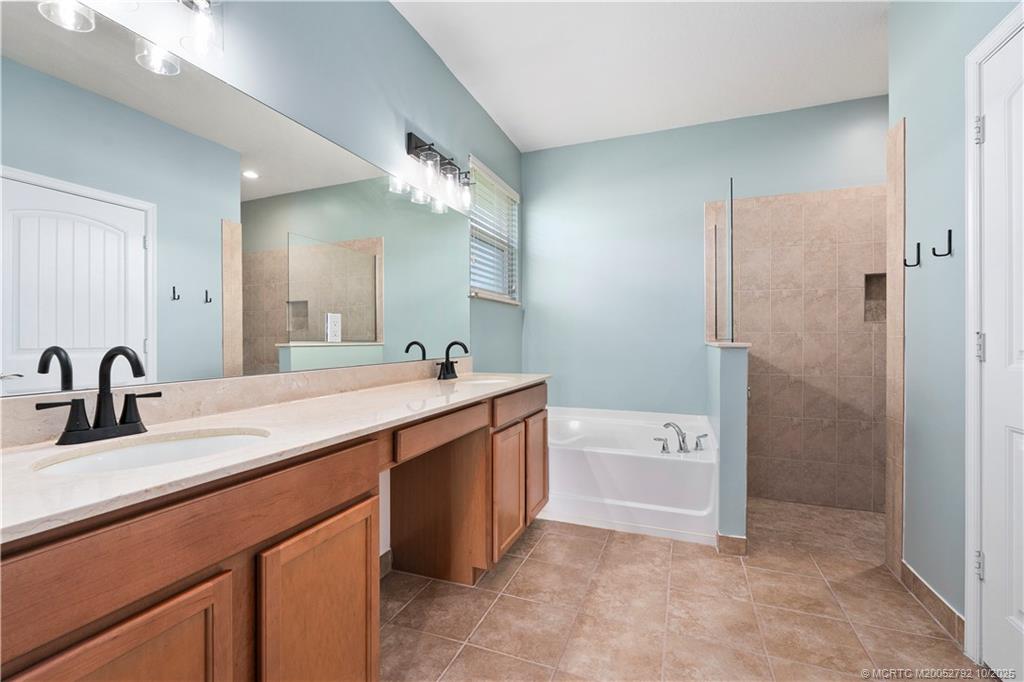 1455 Southeast Conference Circle Stuart, FL 34997 - Photo 27 of 69 a spacious bathroom with a double vanity sink double mirror and bathtub